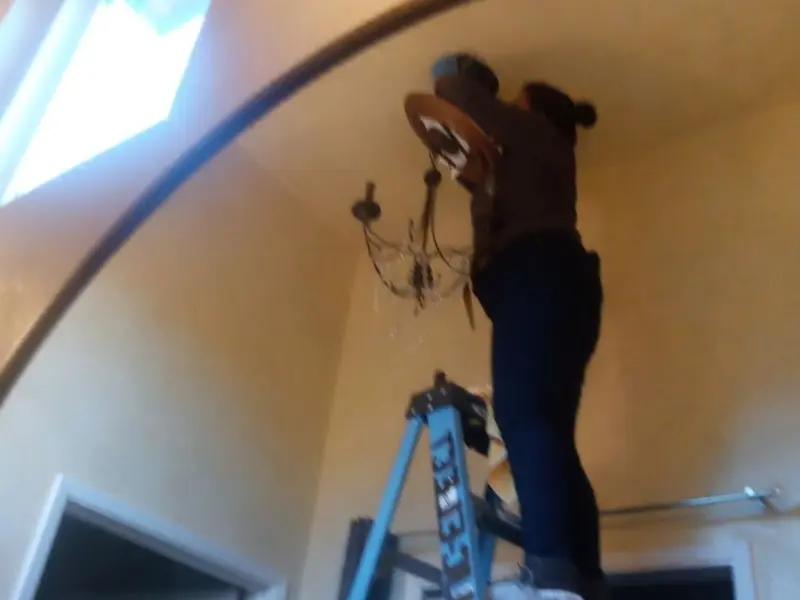 Electrician installing a chandelier in a Bowleys Quarters residence